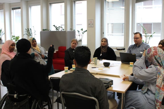 Deltagare på seminariet sitter vid ett bord och samtalar